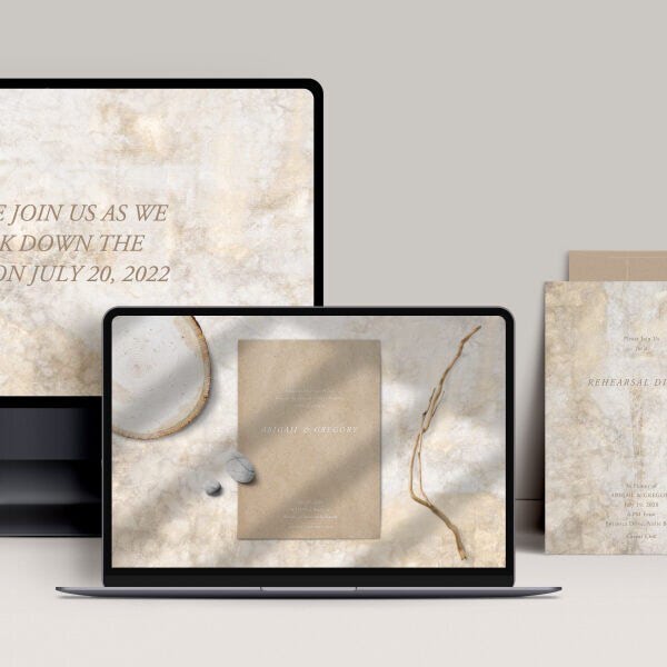 A monitor and laptop screen with a rustic-themed online wedding website and invitation and a matching printed invitation