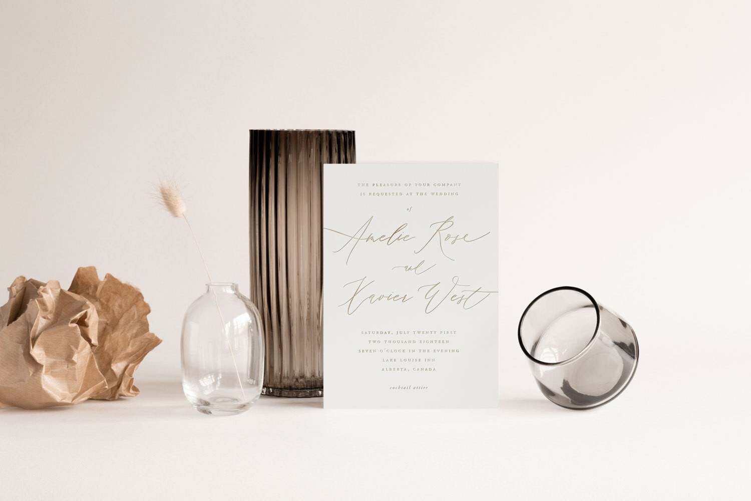 A white wedding invitation with calligraphy for a couple named Amelie and Xavier