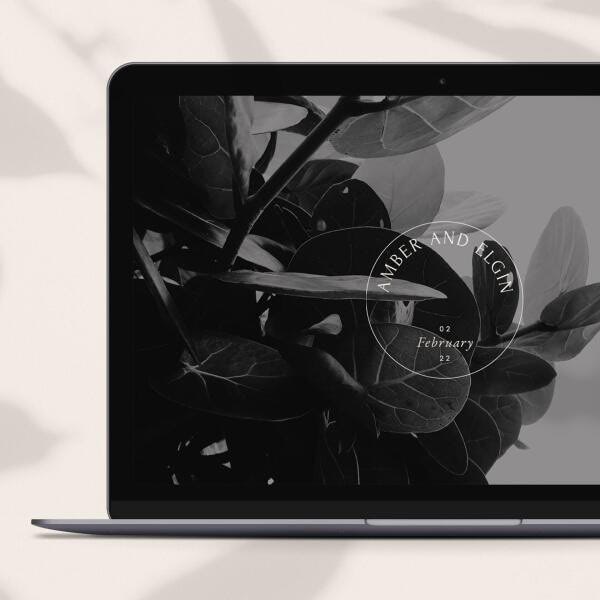 A laptop screen with a leaf-filled wedding website for a couple named Amber and Elgin